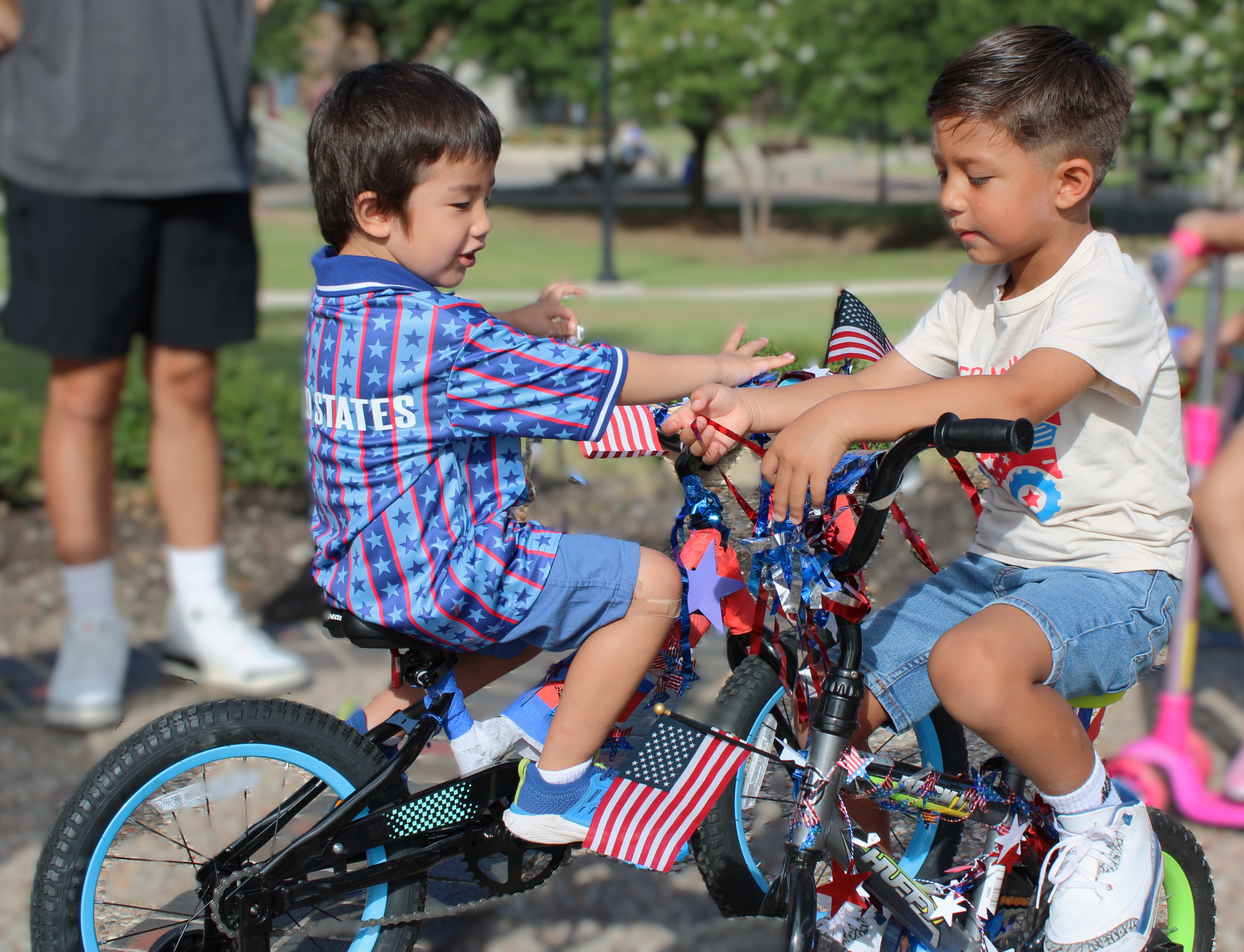 Tyler Hrometz, left, and Bentlee Lamb compare their bicycles, decorated in red, white and blue, before joining the Central Texas College Child Development Center Patriotic Parade celebrating America's 250th birthday.