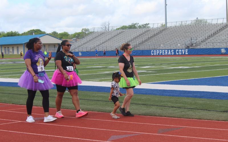 CCLP/BRITTANY FHOLER -- Participants in the Pride of Cove Band &amp; Color Guard’s 3rd annual Marching 5K and Fun Run circle the track at Bulldawg Stadium on Saturday morning.