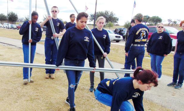 Cadets in the CCHS JROTC Bulldog Battalion carry poles and place them in sections for volunteers to fill with wreaths. More than 6,400 wreaths were retrieved last year by hundreds of volunteers.