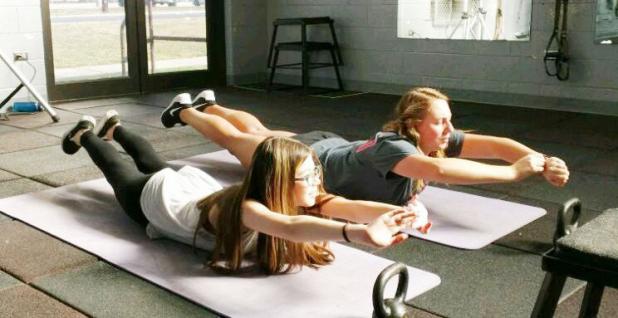 CCHS military students Michayla Medley and Kara McVeigh are holding the Superman pose in a Fort Hood gym during the CYSS quarterly FRIENDS meeting. Soldiers put nearly a dozen CCHS students through rigorous physical exercises.