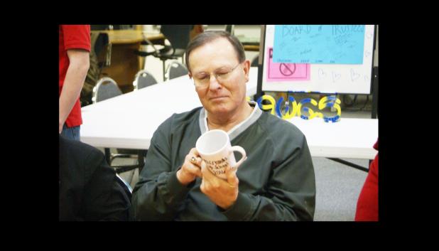 CCISD PHOTO/ JASON MCGUIRE - CCISD Board of Trustees member Mike Wilburn admires the custom-designed coffee mug presented to him by the Crossroads High School student council. Board members were welcome for a luncheon at the school in honor of national School Board Recognition Month.