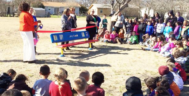 CCLP/DAVID J HARDIN - Fairview/Miss Jewell Students watch as Principal Leah Miller cuts the ribbon opening the new “Buddy Bench” on the campus Friday afternoon