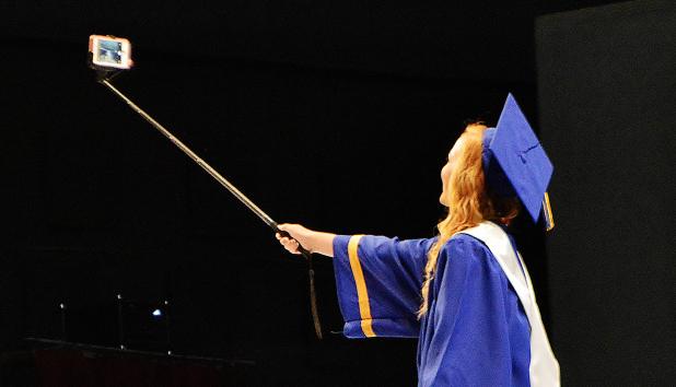 CCLP/LYNETTE SOWELL - Kayla Wilson takes a selfie on stage with her senior class during the commencement ceremony Friday evening at the Bell County Expo Center.