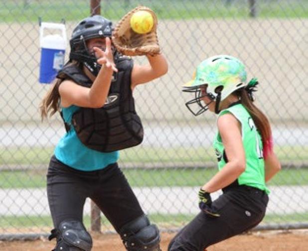 Cove Chaos’ Hallie Kessinger scores as Rockdale Blasters catcher Payton Miller awaits the throw during their game Tuesday in the 2014 TTA Girls 12U State Tournament.