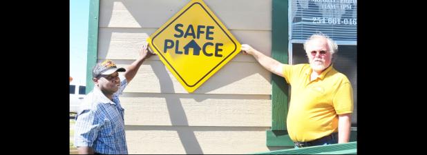 CCLP/DAVID J. HARDIN - Copperas Cove Soup Kitchen director Patrick Richardson and Kelly Jenkins of Central Texas Youth Services hold up the new Safe Place sign, which designates the soup kitchen as a place where at-risk youths can go if they are in trouble and need.