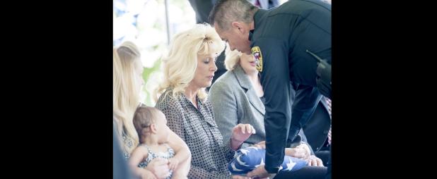 File Photo - Tracy Molnes, widow of chief of police Timothy Molnes, receives his flag during a June 3 memorial service. Molnes passed away on May 30.