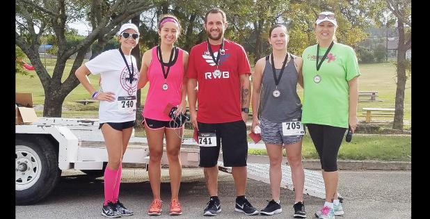 CCLP/PAMELA GRANT - Julie Moser and Jen Reynolds award medals to the 1st, 2nd, and 3rd place winners of the Pink Warrior Angels’ 2nd Annual Pink Warrior Dash 5k run/walk. Alex Wilson came in 1st, Christian Riedenaur came in 2nd, and Chellie Cannon came in 3rd.