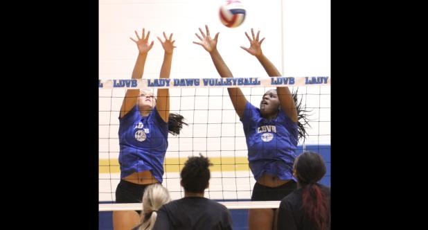 CCLP/TJ MAXWELL - Cove seniors Brianna Acker, left, and Chyanne Chapman attempt a block during the annual alumni game and Meet the Lady Dawgs event held Friday at Bulldawg Gymnasium.