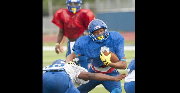 CCLP/DAVID MORRIS - Cove senior running back Elijah Washington attempts to elude a tackler as senior quarterback Caine Garner looks on during the Bulldawgs’ annual Soap, Towel and Shampoo scrimmage Saturday at Bulldawg Stadium.