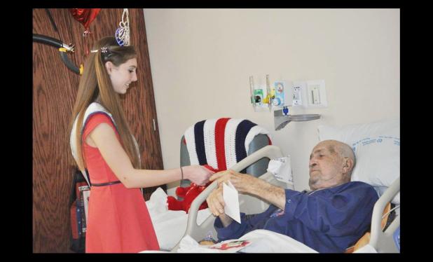 COURTESY PHOTO - Young Miss Rabbit Fest Carleigh Ross, 15, hands a hand-made valentine to a veteran at the Central Texas VA Hospital on Saturday.