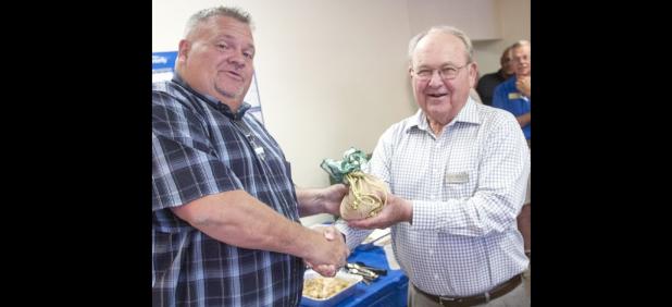 CCLP/DAVID MORRIS - Brian Hawkins, left, accepts a bag of money from Western Insurance president Tom Boren during the monthly Chamber of Commerce Mixer. Western Insurance recently celebrated 40 ears in the Copperas Cove community