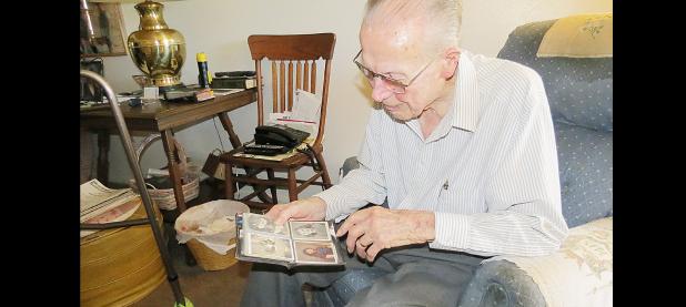 CCLP/BRITTANY FHOLER - Victor Krempin admires photos in his wallet of his wife and daughters, pointing out one where his wife is posing with their eldest daughter, in his home on Oak St.