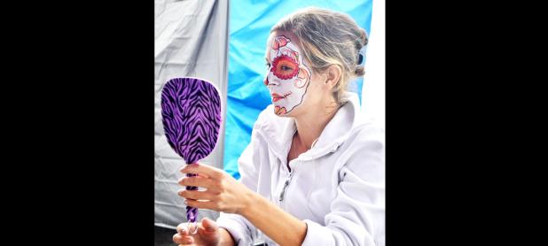 CCLP/LYNETTE SOWELL - A woman inspects her face painting design done by T-Rox Designs at Saturday’s Calaveritas Festival at Central Texas College. The annual Dia De Los Muertos event featured vendors, food trucks and a costume contest.