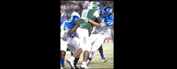 CCLP/DAVID MORRIS - Cove senior defenders Antoine Smith (52) and Lucas Hogue meet at Ellison ball carrier Antares Gilliespie during the Dawgs’ 38-3 win over the Eagles on Thursday.