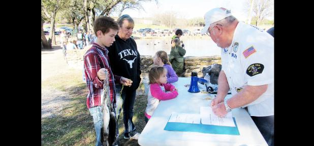 CCLP/BRITTANY FHOLER - Karen Sutton waits with her grandchildren Matthew Thompson, 12, Stormie Wilson, 4, and Isabelle Wilson, 6, to receive their certificates of honorary membership of the Copperas Cove Bass Club for catching their fish at the 10th annual Fishing in the Park event held Saturday morning.