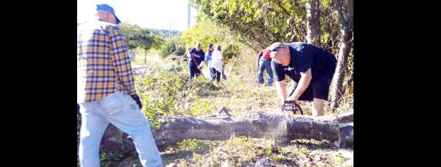 CCLP/LYNETTE SOWELL - Mike Blount and Brian Hawkins cut up a tree at the Sunshine Home apartments on Saturday as part of Make A Difference Day.