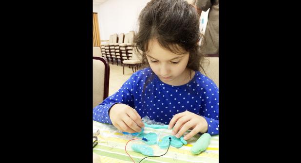 CCLP/DAVID J. HARDIN - Third grader Aubrey Krieger works on connecting lights by using wires and dough at the Dough Circuits workshop on Saturday at the Copperas Cove Public Library. The event was held by the Central Texas Makers Club,