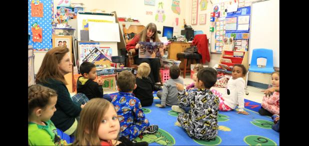 Courtesy Photo CCISD - Benefits Specialist Shirley Bennett reads to students at Mae Stevens Early Learning Academy in conjunction with International Literacy Day. The school used a round robin strategy as students changed classes listening to a variety of guests read aloud books related to the Christmas holiday.