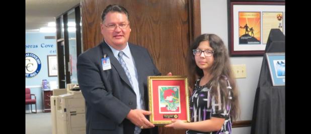 CCLP/BRITTANY FHOLER - CCISD Superintendent Dr. Joe Burns presents Alyssa Walker, a 7th grader at S.C. Lee who won 3rd place in the CCISD Holiday Card contest, with her framed card.