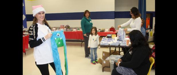 COURTESY PHOTO - Martin Walker Elementary parent Amanda Sawyer volunteers at the school’s Peppermint Village Christmas Store to help students pick out gifts for their family and friends.