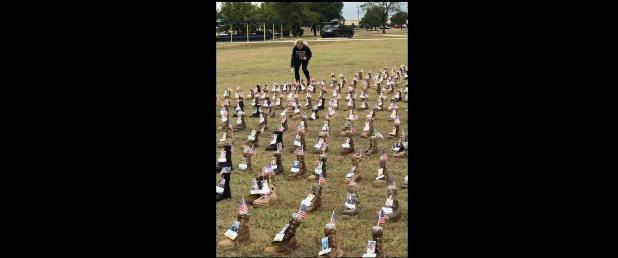 Courtesy Photo - A visitor spends a moment on Saturday at one of more than 7,000 boots on display at III Corps Headquarters on Fort Hood, the site of the 3rd annual Remembrance Run, Walk, Roll. The boots representing more than 7,000 military service members who have passed away since 2001.