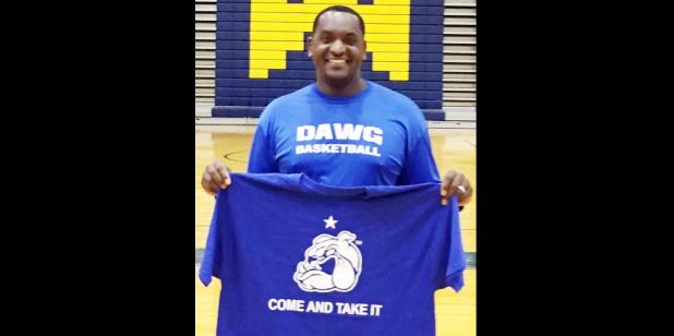 Courtesy Photo - Copperas Cove High School basketball coach Billy White holds up one of the tshirts with the motto of his hometown of Gonzalez. The educator is using the slogan, “Come and Take It” to motivate his players while teaching them history and character education simultaneously.