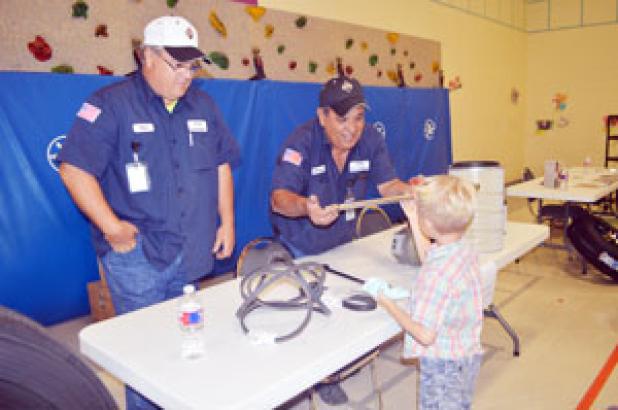 While Michael Haire looks on, Richard Ximinez shows a student one of the massive wrenches CCISD’s transportation department uses to maintain and repair buses at Friday’s Career Day at Williams-Ledger Elementary.