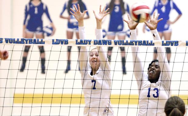 CCLP/TJ MAXWELL -- Cove junior Chyanne Chapman, right, leaps for one of her eight solo blocks in the five-set win over No. 30 Midway on Friday.