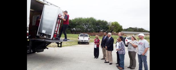 CCLP/PAMELA GRANT - Clarence Enochs, Josh Alvarez, Debbie Peredo, Angie Sargent, Bo Roldan, and Mayor Frank Seffrood watch as a new freezer is delivered to the Cove Meals on Wheels program.The new appliance was donated and will double the amount of people that the group is able to help.