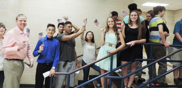 COURTESY PHOTO - Copperas Cove Junior High students wave American flags donated by the Noon Exchange Club of Copperas Cove as part of the Exchange’s Give a Kid a Flag to wave project. The students were given the flag as they passed through the cafeteria doors prior to the May 26 award ceremonies. The project was designed to strengthen Americanism and patriotism.