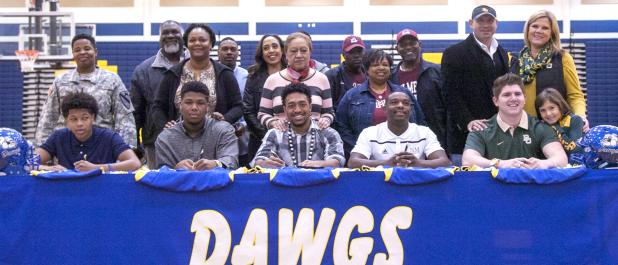 CCLP/DAVID MORRIS - Copperas Cove football players, from left, Ra’Shaun Henry (Saint Francis - Pennsylvania), Josh Klenclo (Tyler Junior College), Antonio Lealiiee Texas A&M-Commerce), Shamad Lomax (New Mexco State) and J.P. Urquidez (Baylor) pose with family members during Wednesday’s signing ceremony in Bulldawg Gymnasium.