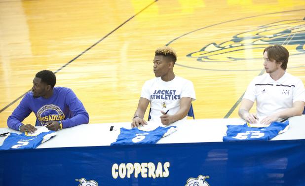 CCLP/DAVID MORRIS - Copperas Cove football players from left: Quarterback Caine Garner (Division III University of Mary-Hardin Baylor), running back Elijah Washington (Div. III Howard Payne University) and deep snapper Sean Adams (Div. I New Mexico State) listen as associate head coach and offensive coordinator Tracy Welch speaks during a signing ceremony Wednesday at the school.