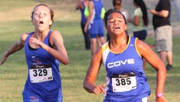 Copperas Cove sophomore Amber Boyd, right, races past Temple’s Ashley Raynard on her way to a second place finish during the Temple Invitational cross country meet Friday at Temple Lions Park.