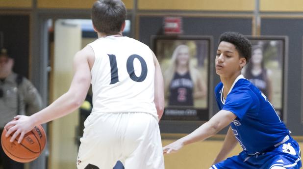 CCLP/TJ MAXWELL - Cove junior Neyland Block defends Lake Travis junior Ben Hoellwarth during the Dawgs’ 65-54 loss to the Cavs on Tuesday.