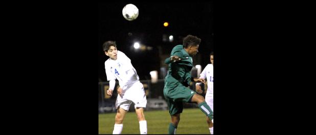 CCLP/TJ MAXWELL - Cove’s Isaac Griffin fights for a header attempt with Ellison’s Ahmad Holt during their 12-6A contest on Friday. Ellison edged out Cove 3-2.
