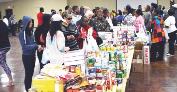 CCLP/LYNETTE SOWELL - Covites make their way through the line as they pick up baskets of food collected by the Refuge Corporation