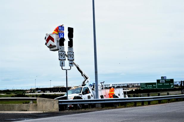 CCLP/LYNETTE SOWELL A TxDOT worker removes the cover of an Interstate 14 sign for the exit at the intersection of Bell Tower Drive and Highway 190 in Killeen. Interstate 14 stretches from Belton to the eastern boundary of Copperas Cove.