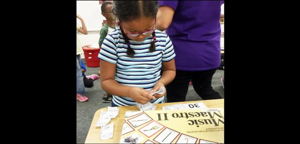 Courtesy Photo/CCISD - Williams/Ledger Elementary student Dayaxie Rodriguez, 6, counts the Hoot Loot money she has earned for good behavior to determine if she has enough to purchase a board game. In addition to encourage positive expectations, the school’s rewards program also teaches students financial literacy.
