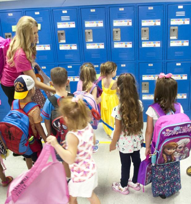 Devin Kasa helps her class find their lockers during the first morning session at Mae Stevens Early Learning Academy.