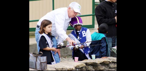 CCLP/WILLY ORTIZ- Jasper Johnson help kids at the annual Fishing in the Park event held on Saturday at city park.
