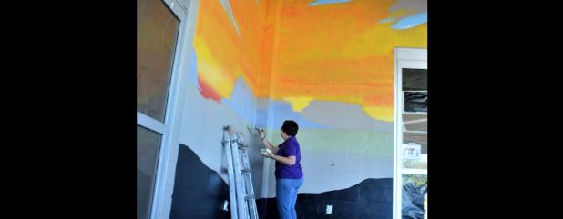 CCLP/LYNETTE SOWELL - Five Hills Art Guild mural project director Sheri Wilson works at blocking areas of the guild’s mural at the future Sutherlands Home Base store, set to open in March.