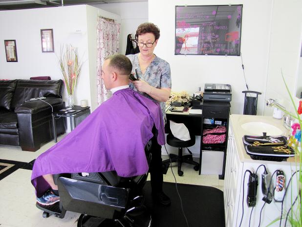 CCLP/PAMELA GRANT<br>Elizabeth Littlejohn trims Kevin Esfahuni’s hair. Littlejohn is the owner of Paisley Barber Shop & Salon in Cove Terrace Shopping Center.