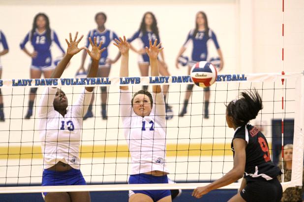 CCLP/TJ MAXWELL -- Copperas Cove juniors Chyanne Chapman (13) and Brianna Acker (17) combine for a block on the shot of Harker Heights senior Kennedi Foster during their 3-1 win on Tuesday. 