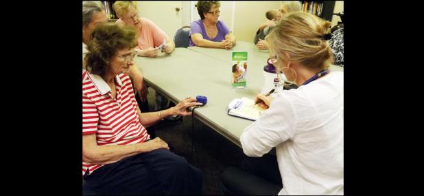 CCLP/PAMELA GRANT - Jamie Moseley checks the blood pressure, oxygen, and pulse rate of Anita Dimmack at the free health screening at the Senior Citizen Center.