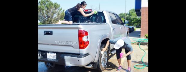 CCLP/LYNETTE SOWELL - Kori Ramos and Kimmie Russell wash down a truck on Saturday morning at Buddy’s on Business 190. Pink Warrior Angels washed cars to help the Pride of Cove Band purchase pink plumes to wear with their uniforms for October’s Pink Out game this fall.