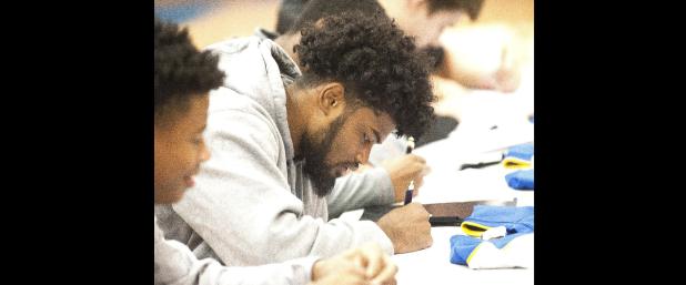 CCLP/DAVID MORRIS - Copperas Cove senior Kylan Herrera participates in a signing ceremony with football teammates Tariq Anthony, Tyson Curry and Bryant Willams; along with golfer Caden McAnally during National Signing Day festivities Wednesday in the high school gym.
