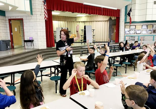 COURTESY PHOTO - Williams/Ledger Elementary principal Marla Sullivan asks students how many of them will make straight A’s on their report cards the next six weeks so they can attend Sweets with Sullivan. All 40 students in attendance raised their hands.