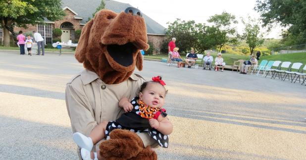 CCLP/DAVID J HARDIN - McGruff the crime dog holds little Skylar at the National Night Out Block party on Kim Avenue, held Tuesday October 3rd, the annual National Night Out Program is designed to build a partnership between neighbors and the police.
