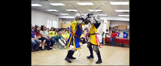 CCLP/LYNETTE SOWELL - Members of the Society for Creative Anachronism perform an armored combat demonstration at Wednesday morning’s summer reading program kickoff.