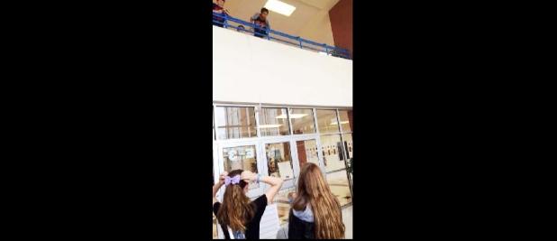 COURTESY PHOTO - S. C. Junior High students launch bungeed Barbie Dolls from the second story inside balcony using rubber bands to gather and graph data on the motion of a falling object as part of a science experiment.